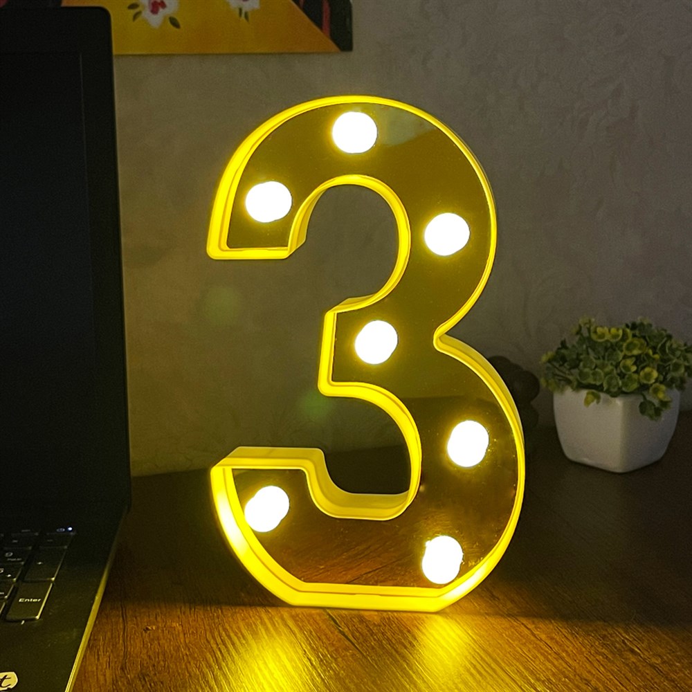 Osvijetljeni žuti broj tri na proizvodu TRI 3 LAMPA