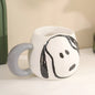 Bijela keramička šalica s sivom ručkom i crnim crtežom Snoopy lica u proizvodu snoopy šaljica siva