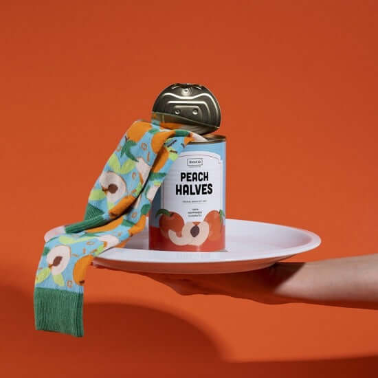 Canned peach halves with colorful cheerful socks in a unique product display
