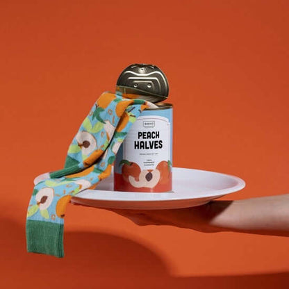 Canned peach halves with colorful cheerful socks in a unique product display