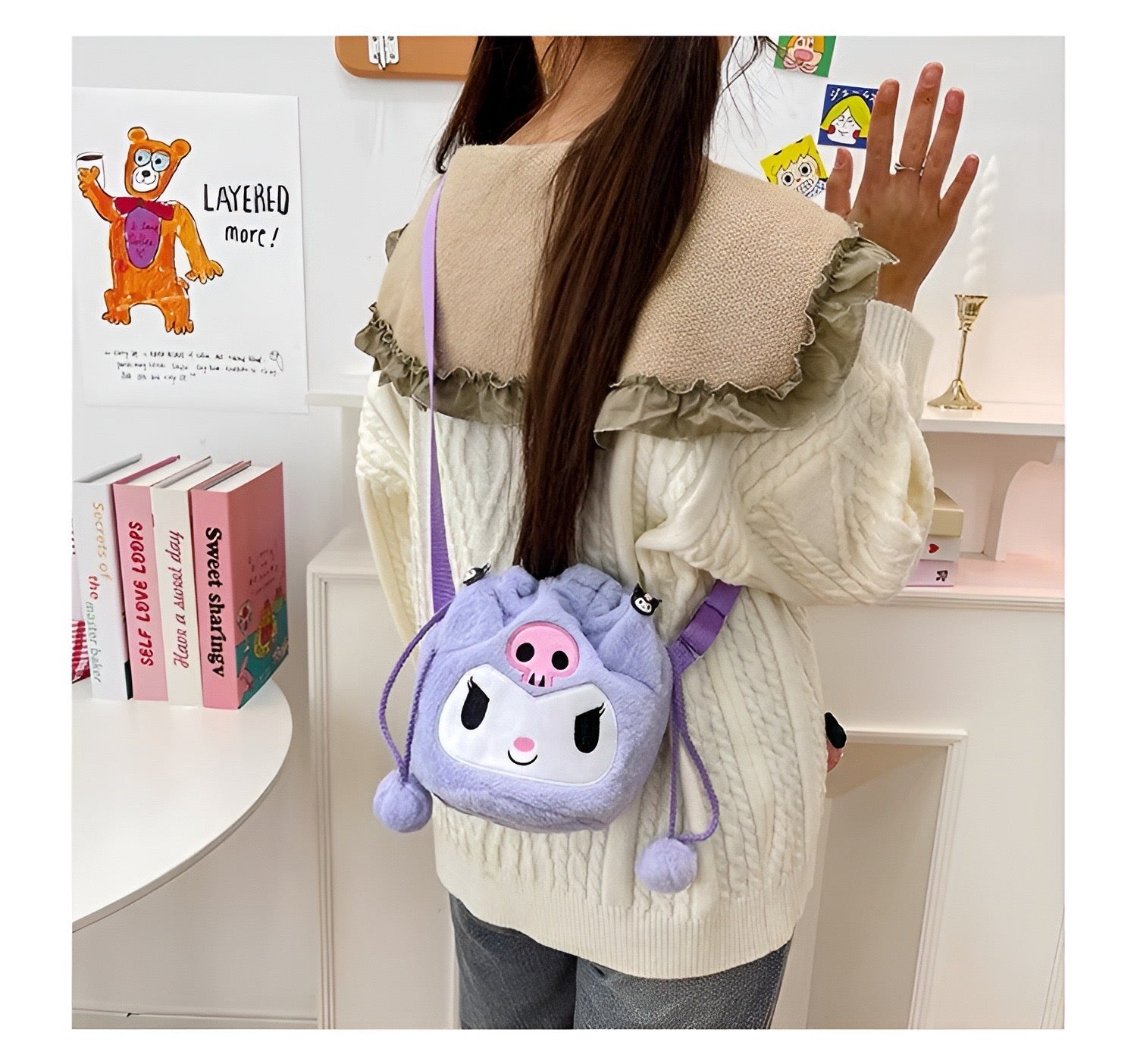 Mekana lila plush torbica kuromi s crnim očima i ružičastim nosom ukrašena pom pom resama na zatvaranju
