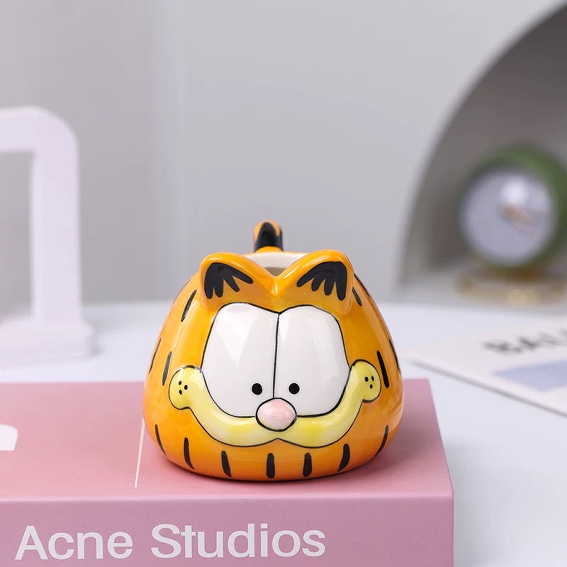 Narančasti Garfield keramički figurin s crnim prugama i bijelim licem, Acne Studios dizajn