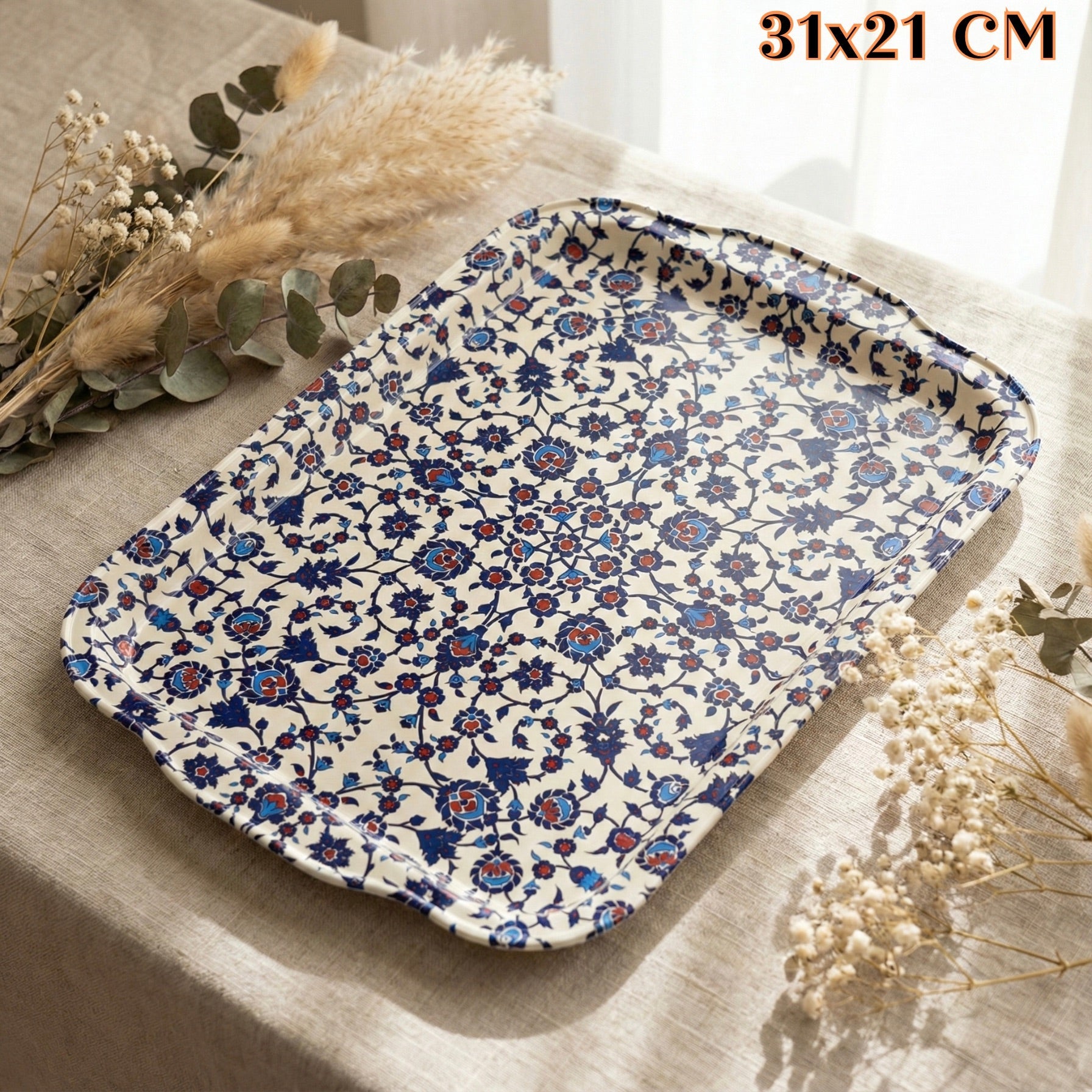 Tradicionalna metalna tacna s plavim i crvenim cvjetnim uzorkom na bijeloj podlozi