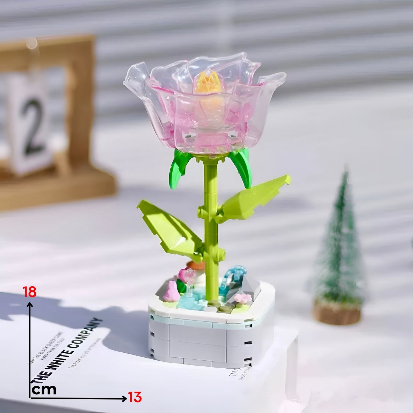 Translucent pink lego kristalna ruža with yellow center green stem leaves assembled on white base