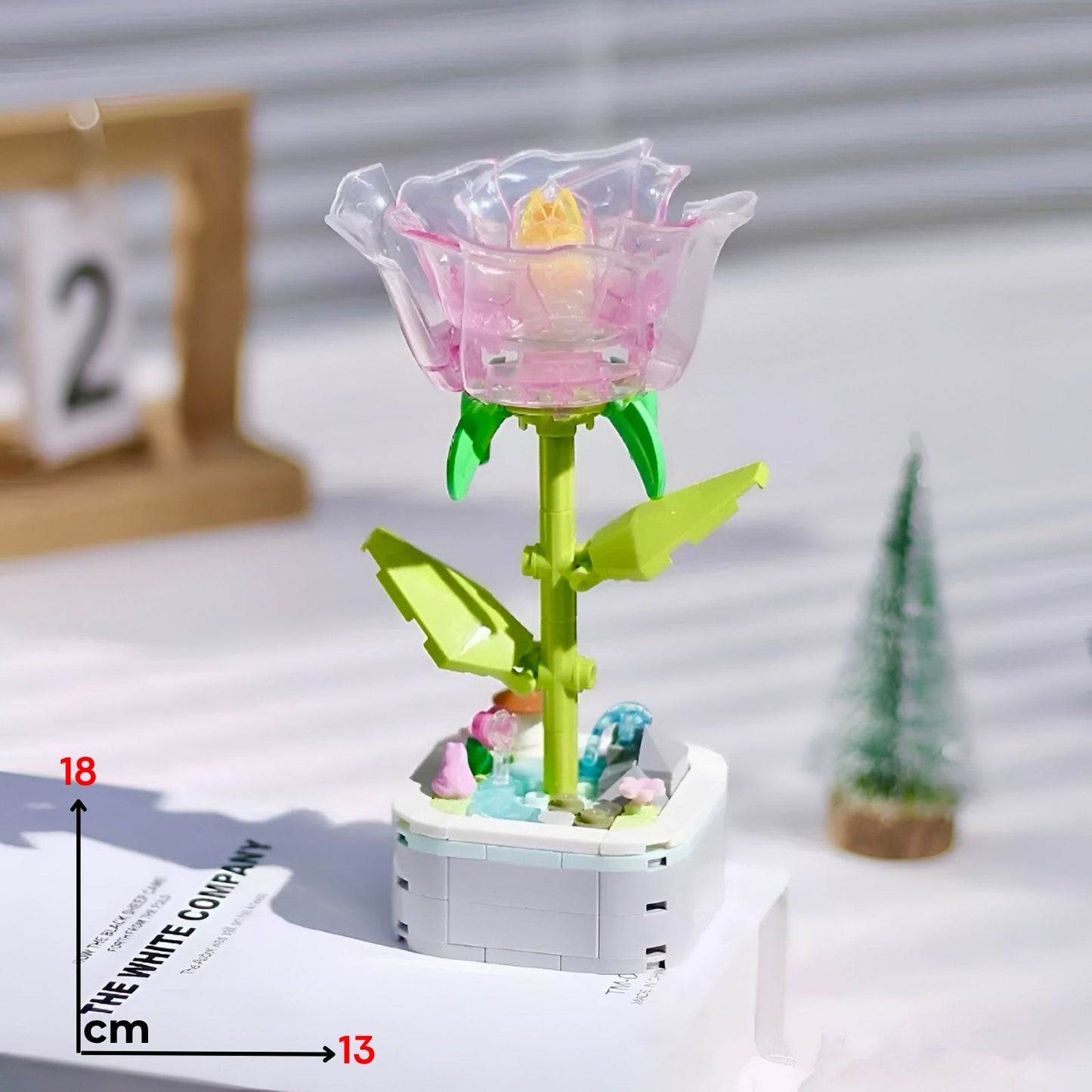 Translucent pink lego kristalna ruža with yellow center green stem leaves assembled on white base