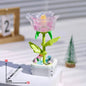 Translucent pink lego kristalna ruža with yellow center green stem leaves assembled on white base