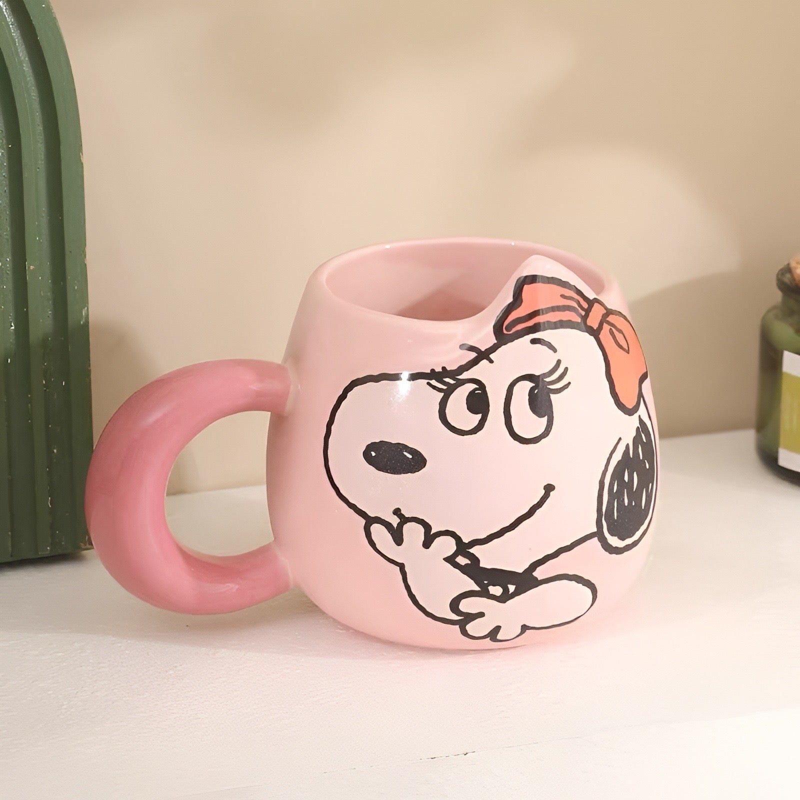 Roza keramička snoopy šolja s crtanim likom snoopyja u narančastoj mašni idealna za kavu