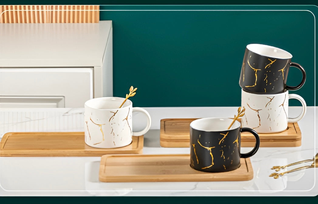 Marble-patterned KERAMIČKA ŠOLJA SET with gold spoons on wooden trays for elegant dining