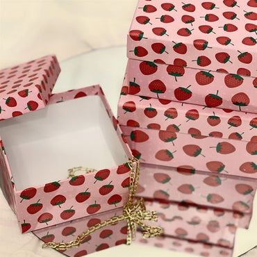 Strawberry-patterned ukrasna kutija with a gold chain for elegant gifting